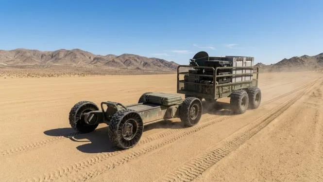 Illustration of a VARAN ground vehicle towing equipment across desert terrain